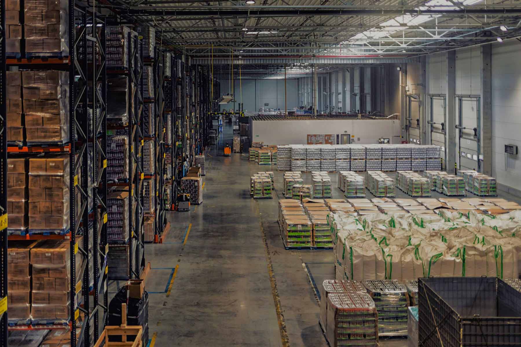 Packing house warehouse inventory aisles with stacked product pallets