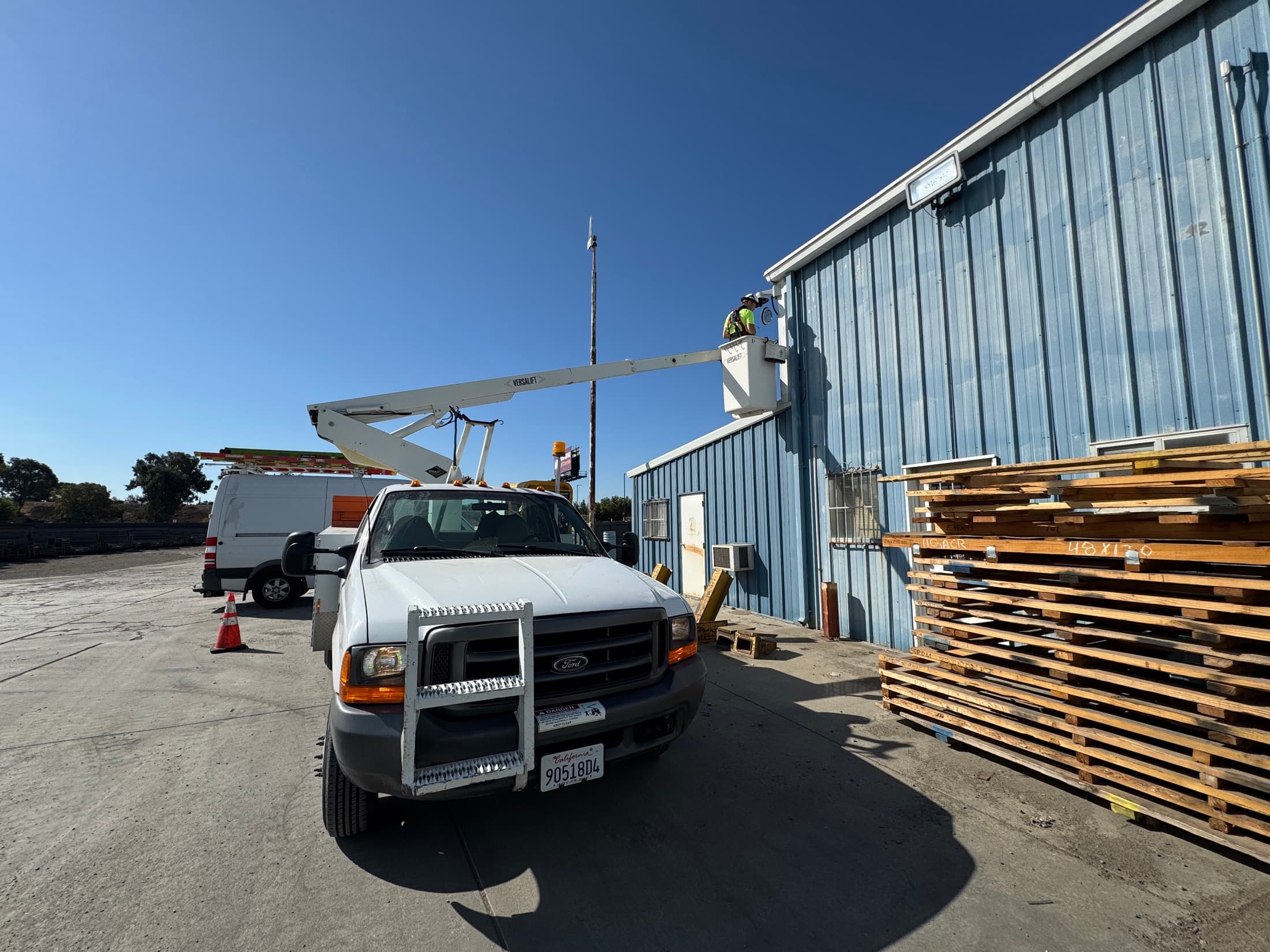 Technician using a bucket truck to work on an exterior commercial building