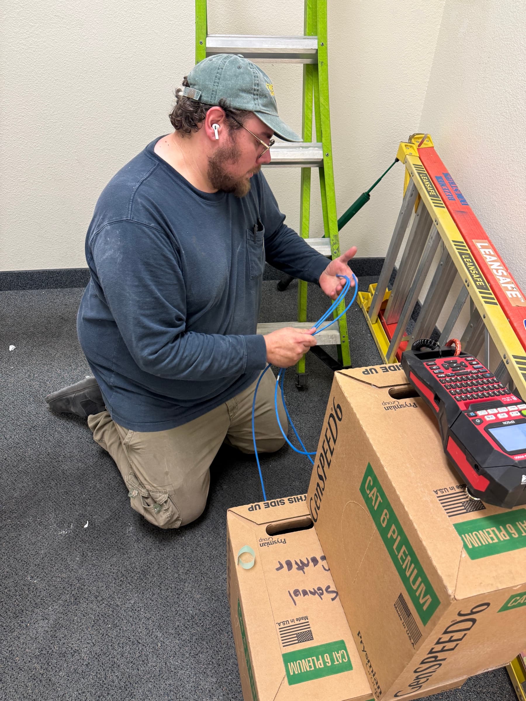 Technician preparing commercial network cabling for coordinated low-voltage work