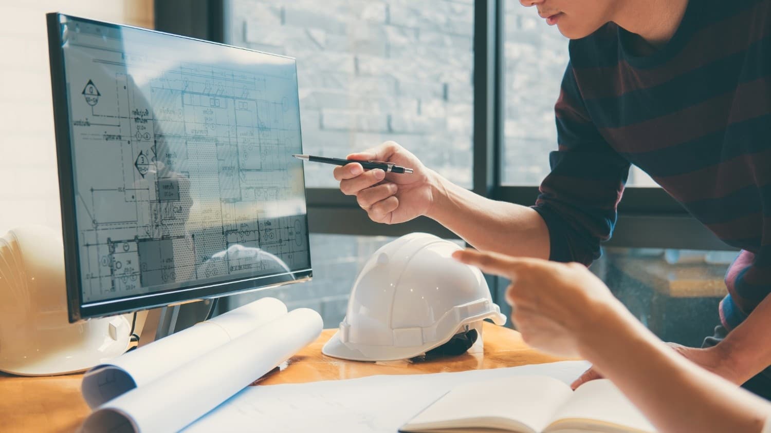 Architects reviewing construction blueprints on a computer screen